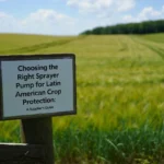 Wooden sign in a green agricultural field with text about selecting the right sprayer pump for Latin American crop protection.